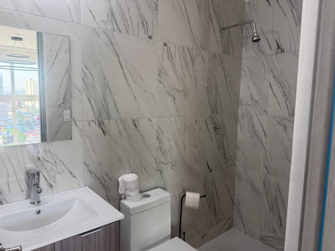 Modern bathroom with marble tiles and walk-in shower in PH El Botánico Panama City
