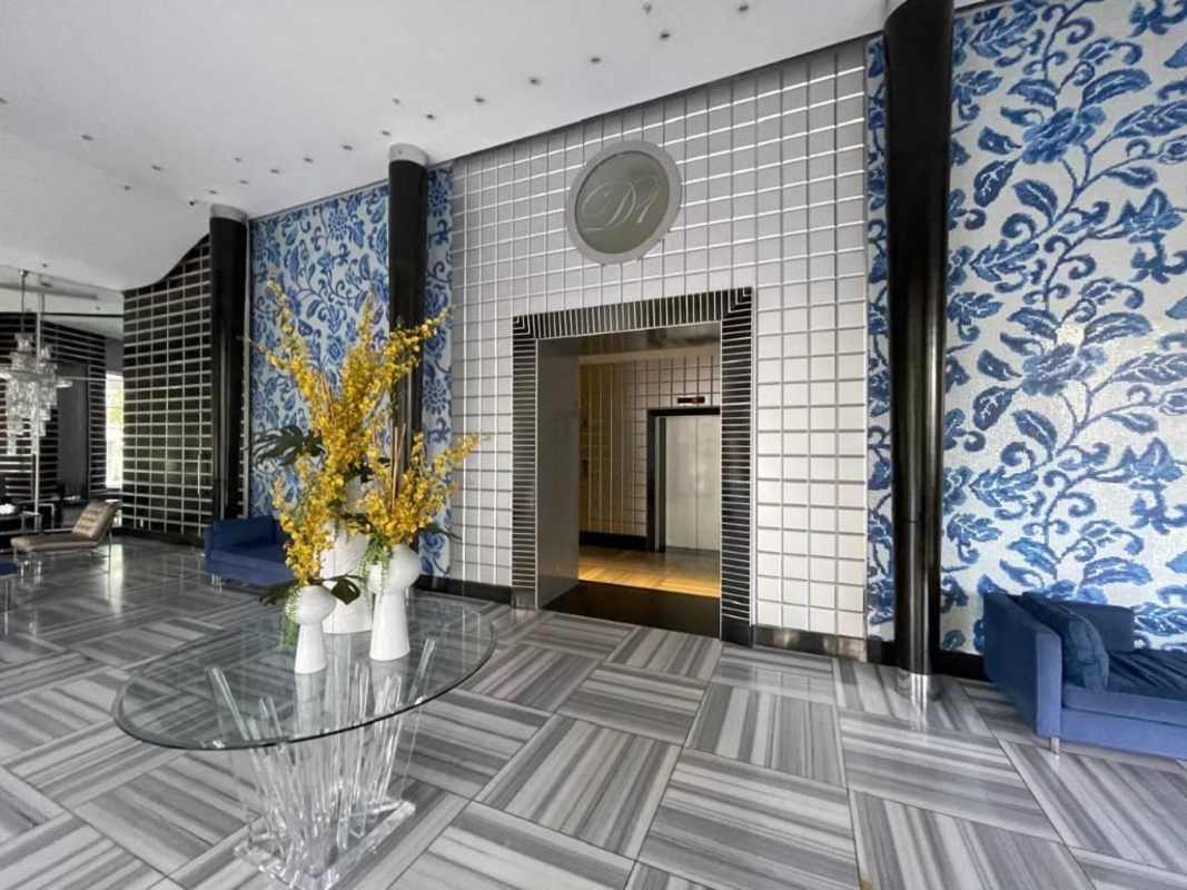 Contemporary lobby with blue accent wall, sofas and floral design in PH D1 Punta Paitilla