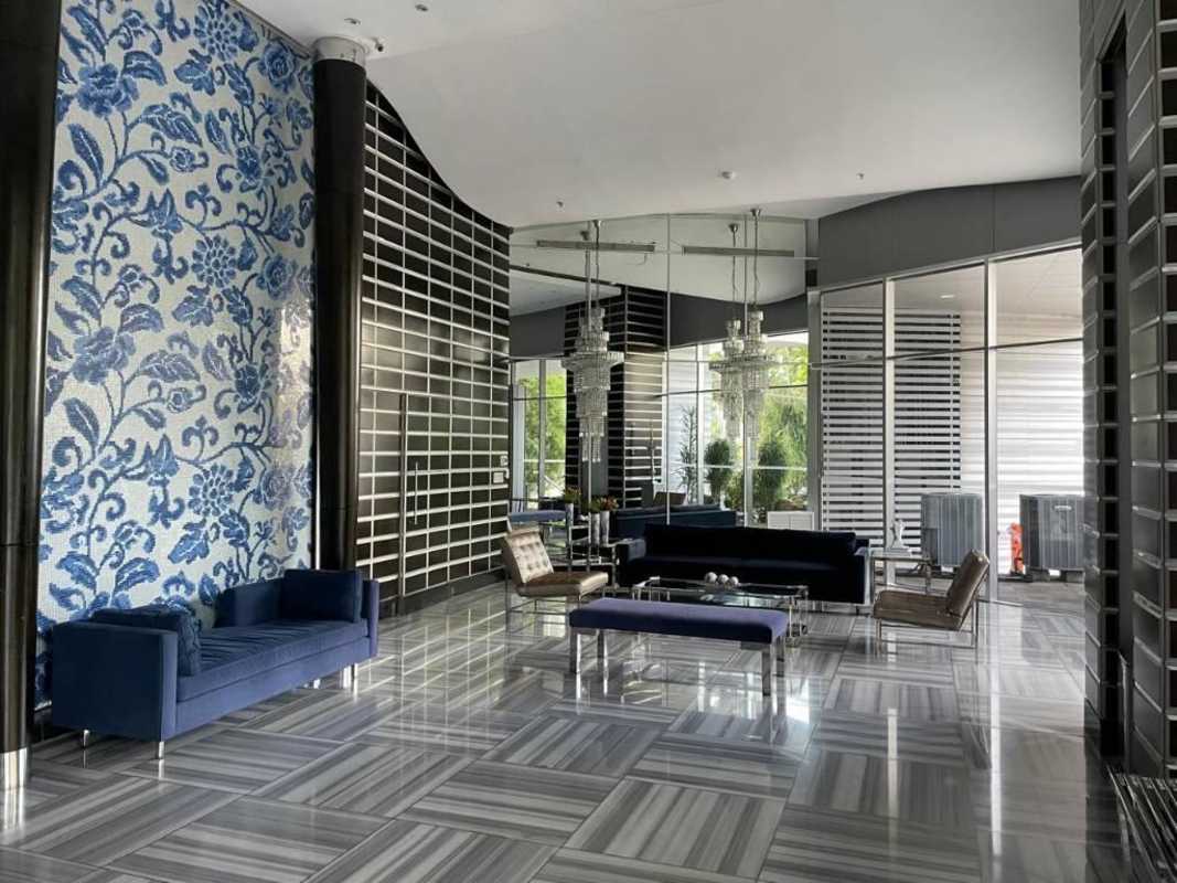 Modern lobby with blue sofas, mirrors, glass tables at PH D1 Punta Paitilla Panama