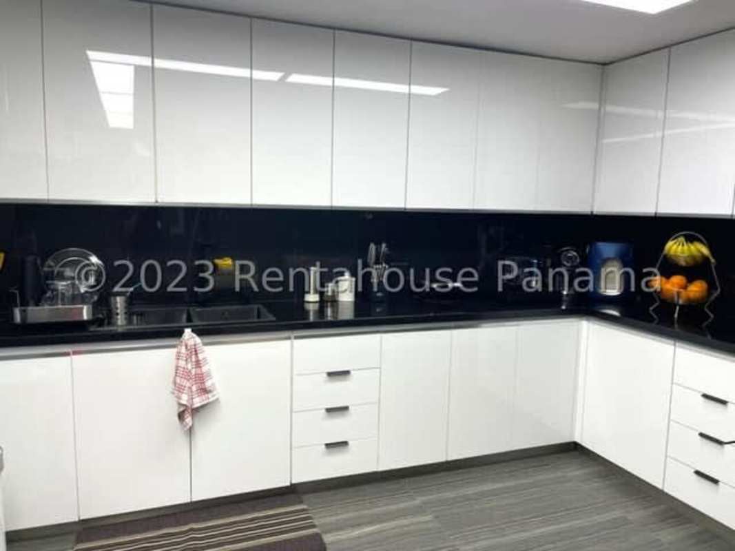 Dining room with contemporary chandelier, glass table and window views in Punta Paitilla condo