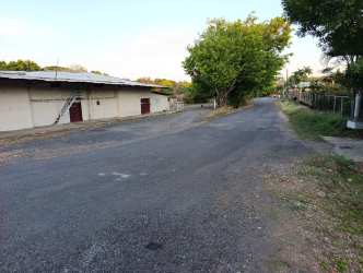 Street entrance with fencing and trees leading to commercial complex in Santiago de Veraguas Panama