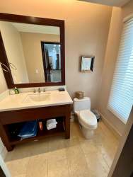 Covered outdoor terrace with lounge and dining facing lake and pool at Buenaventura Bristol Villas Panama