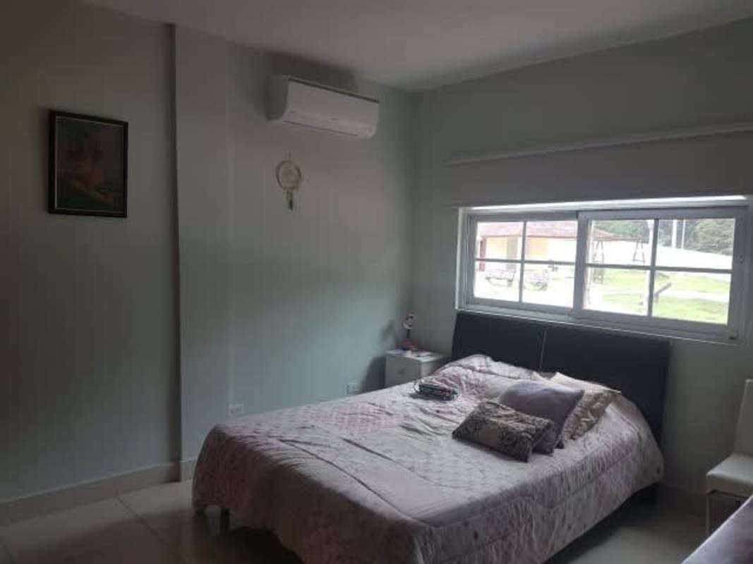 Bedroom with large window, AC unit and natural light in Clayton house