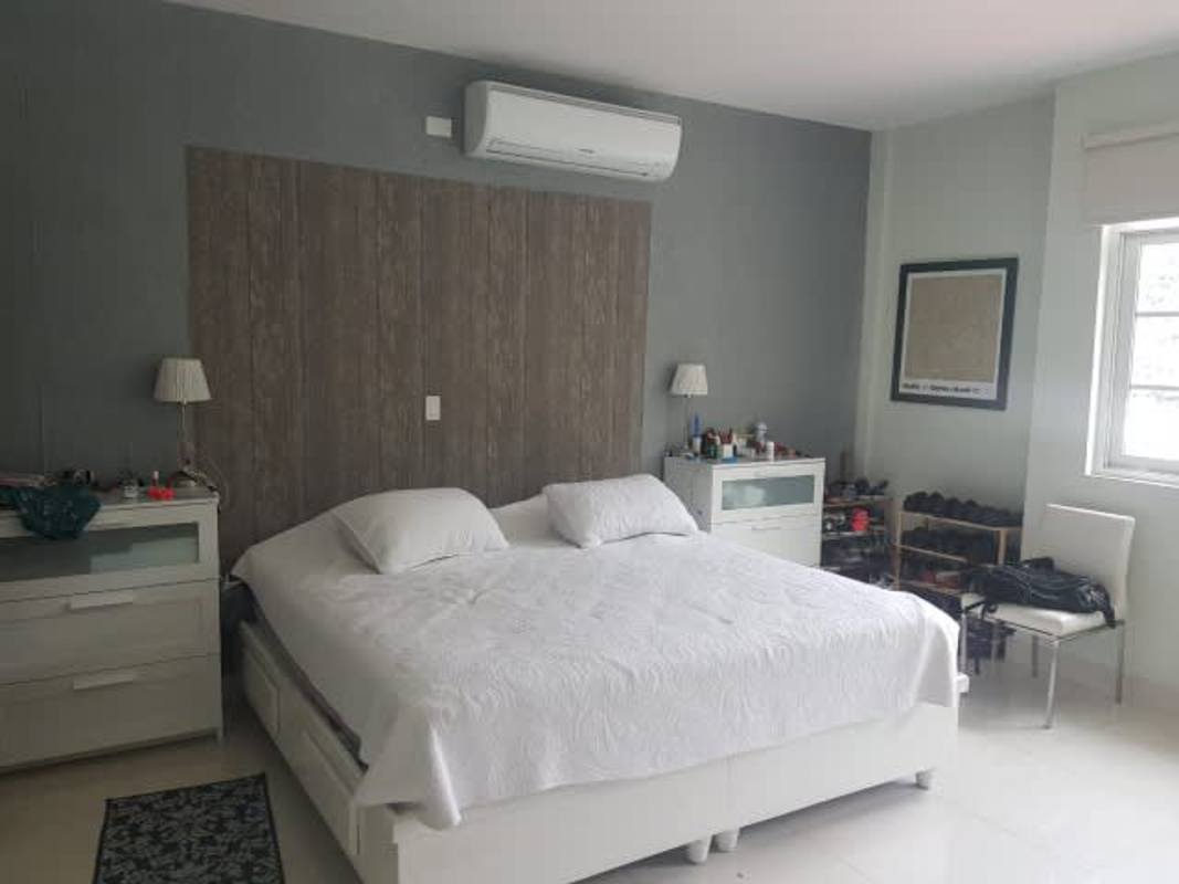 Master bedroom with ensuite bathroom and large windows in Clayton residence Panama