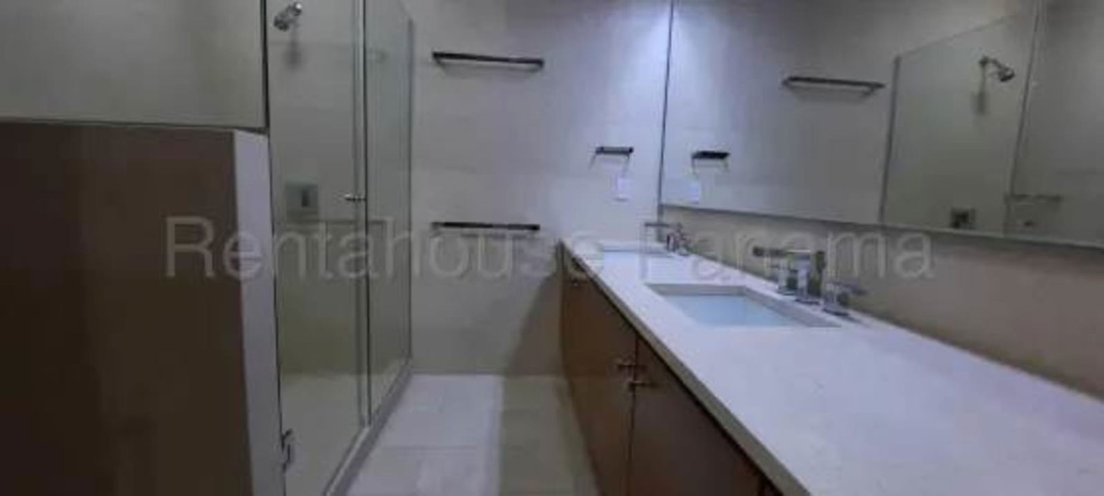 Elegant bathroom with large mirrors, glass shower, and marble countertop in Sky Residence Panama