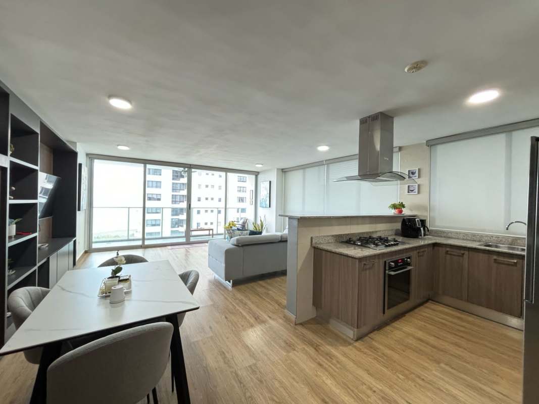 Bedroom with wood floors, large mirror, blue bedding, modern décor at PH Lumiere Panama