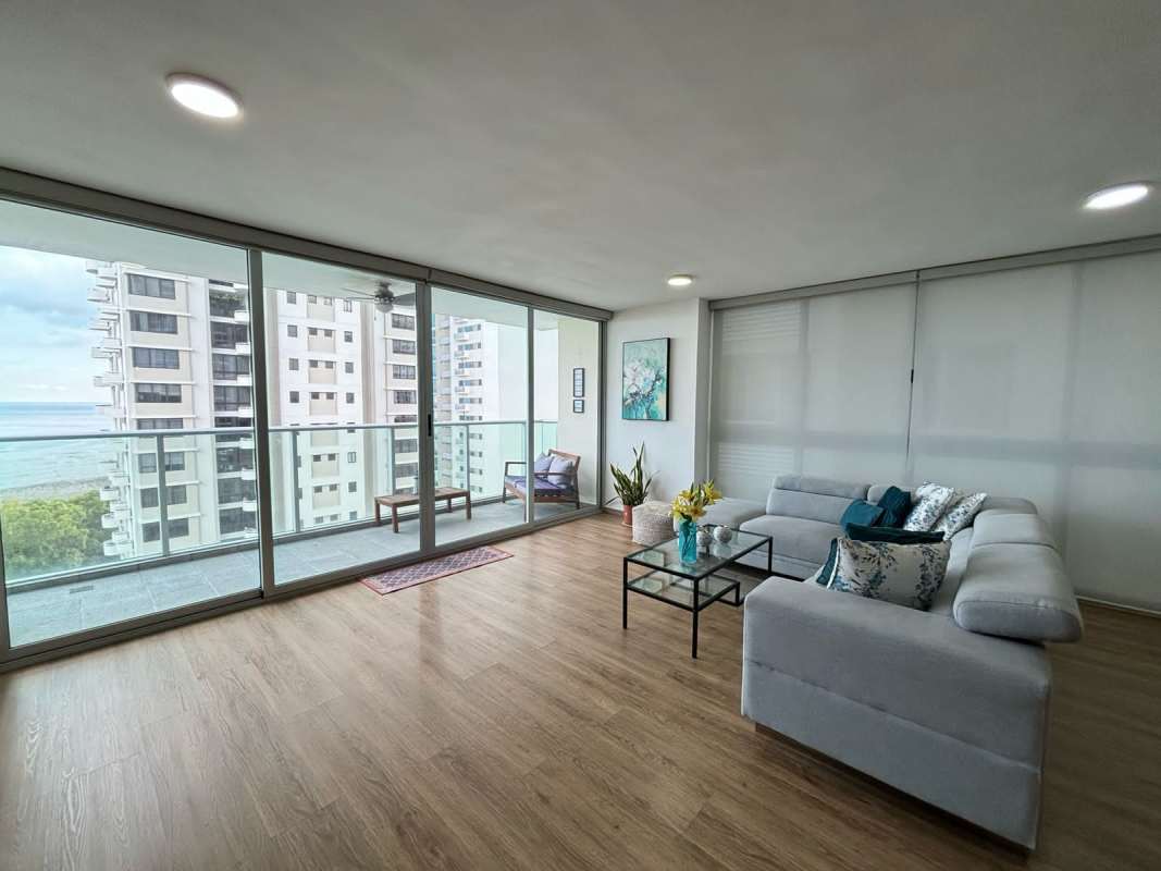 Spacious modern living room featuring floor-to-ceiling windows, glass doors to balcony with ocean view at PH Lumiere Costa del Este