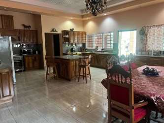 Large kitchen and dining with wood cabinetry in Volcán Panama estate home