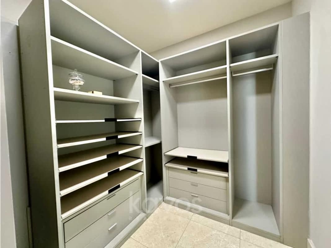 Spacious walk-in closet with fitted shelves and drawers in luxury apartment Santa María Panama