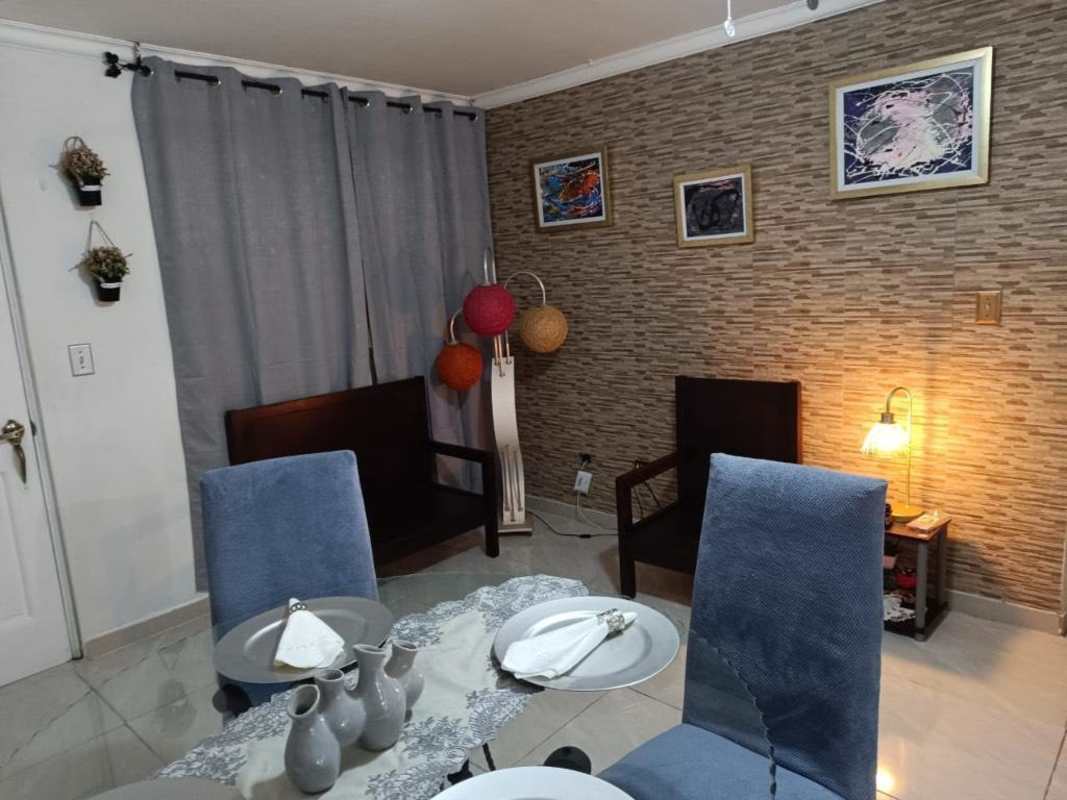 Dining area with brick accent wall, blue chairs, contemporary decor in PH Mystic Park Panama City