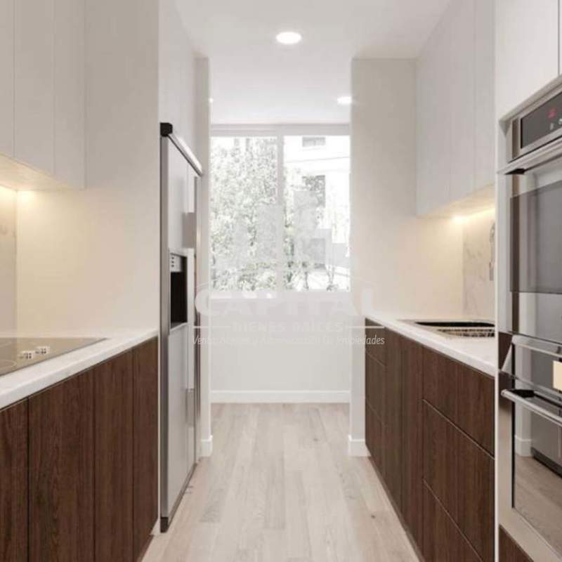 Galley kitchen with marble backsplash, built-in appliances, natural light at PH Lemon Bella Vista