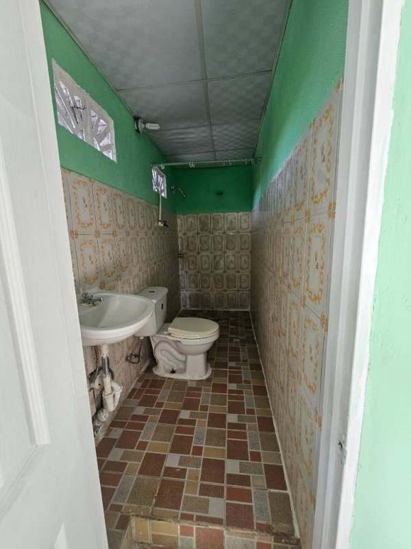 Empty bedroom with tiled floor, green walls, natural light in rental room Panama City