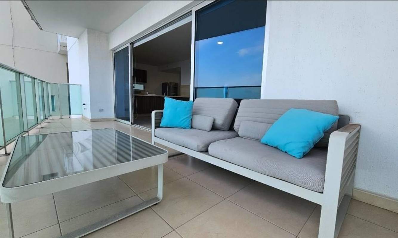 Modern living room with large windows, gray sofas, yellow accents, ocean views Punta Pacifica Panama