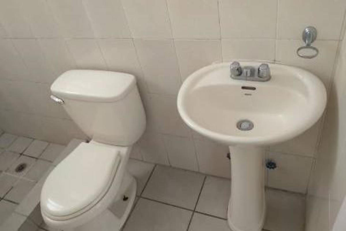 Full bathroom with tiled walls walk-in shower and pedestal sink PH Plaza Valencia Panama