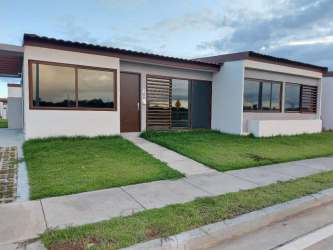 Single-story modern house facade with front lawn and driveway in Senderos de Santa Monica Panama