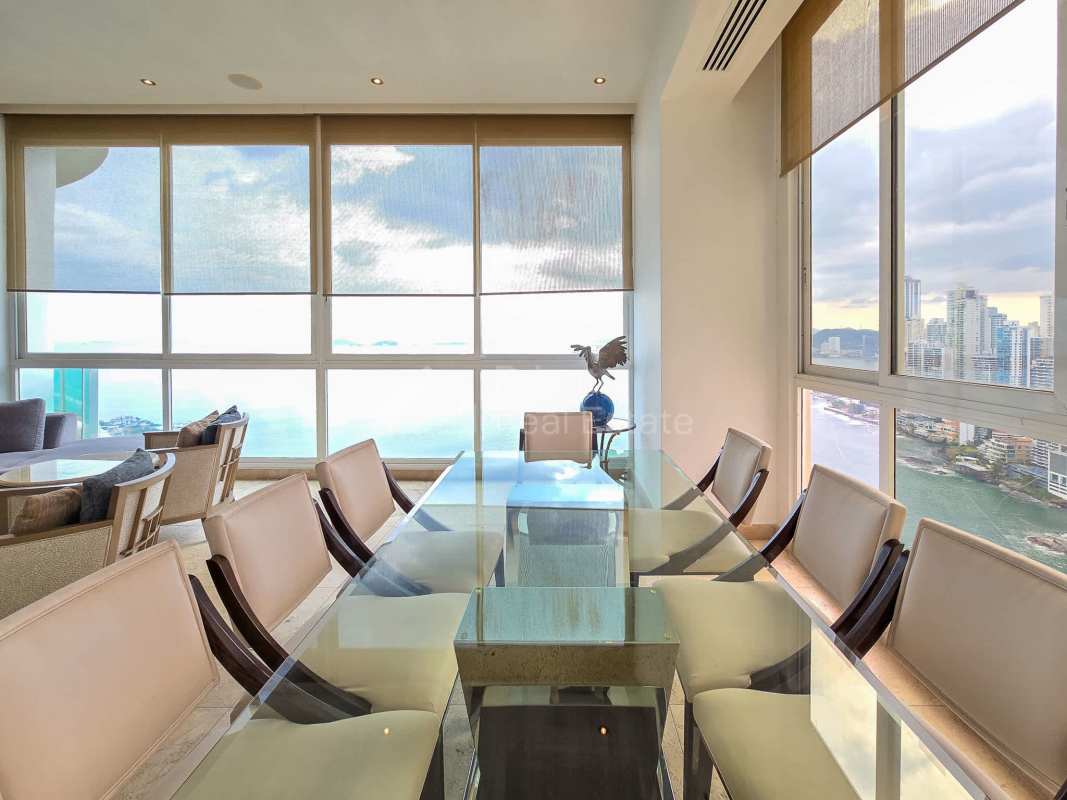 Minimalist bedroom with large windows overlooking Pacific Ocean, wood floors in Punta Pacífica condo