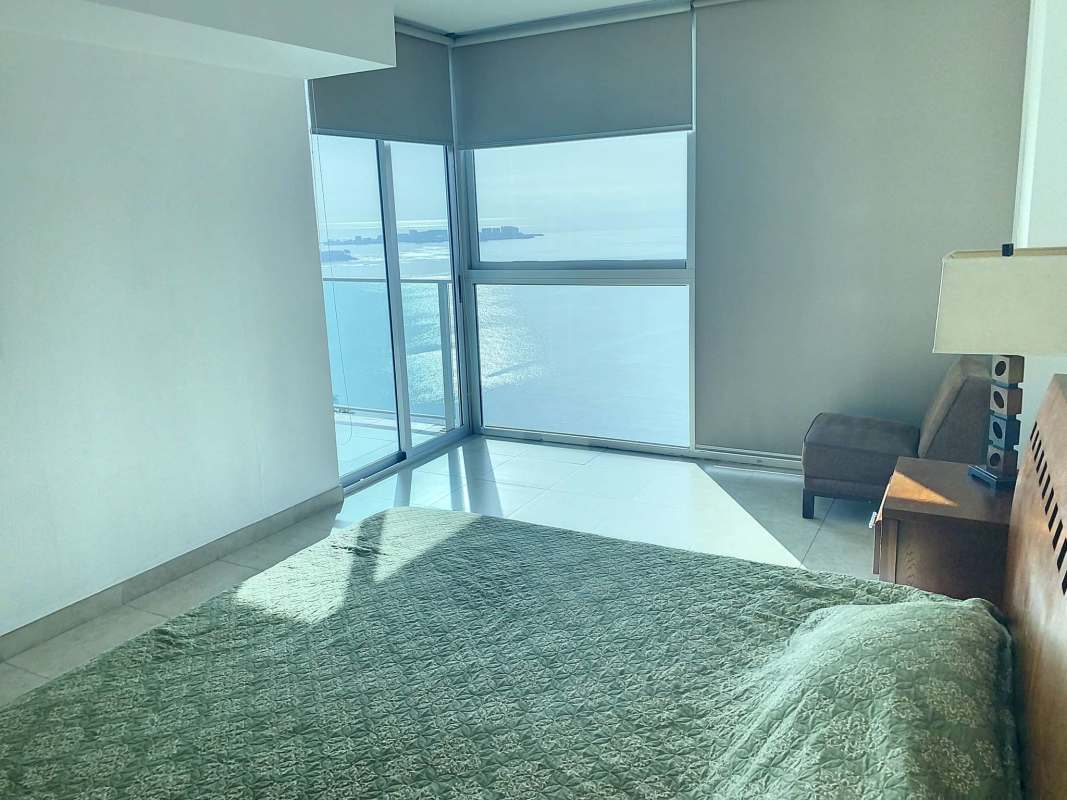 Large master bedroom with floor-to-ceiling windows and oceanfront views in PH H2O Panama City