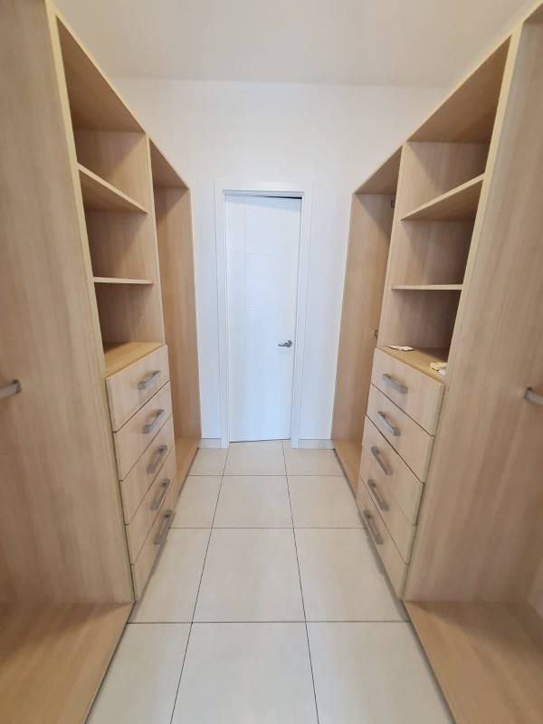 Modern walk-in closet with shelves and drawers in master bedroom PH Waters on the Bay