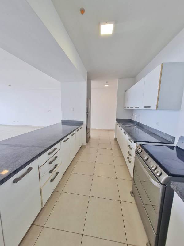 Bright open kitchen with granite counters, white cabinetry, stainless appliances at Waters on the Bay Panama