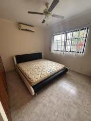 Traditional kitchen with wooden cabinets, ceramic countertops, gas stove and large window in Villa Mercedes David Panama