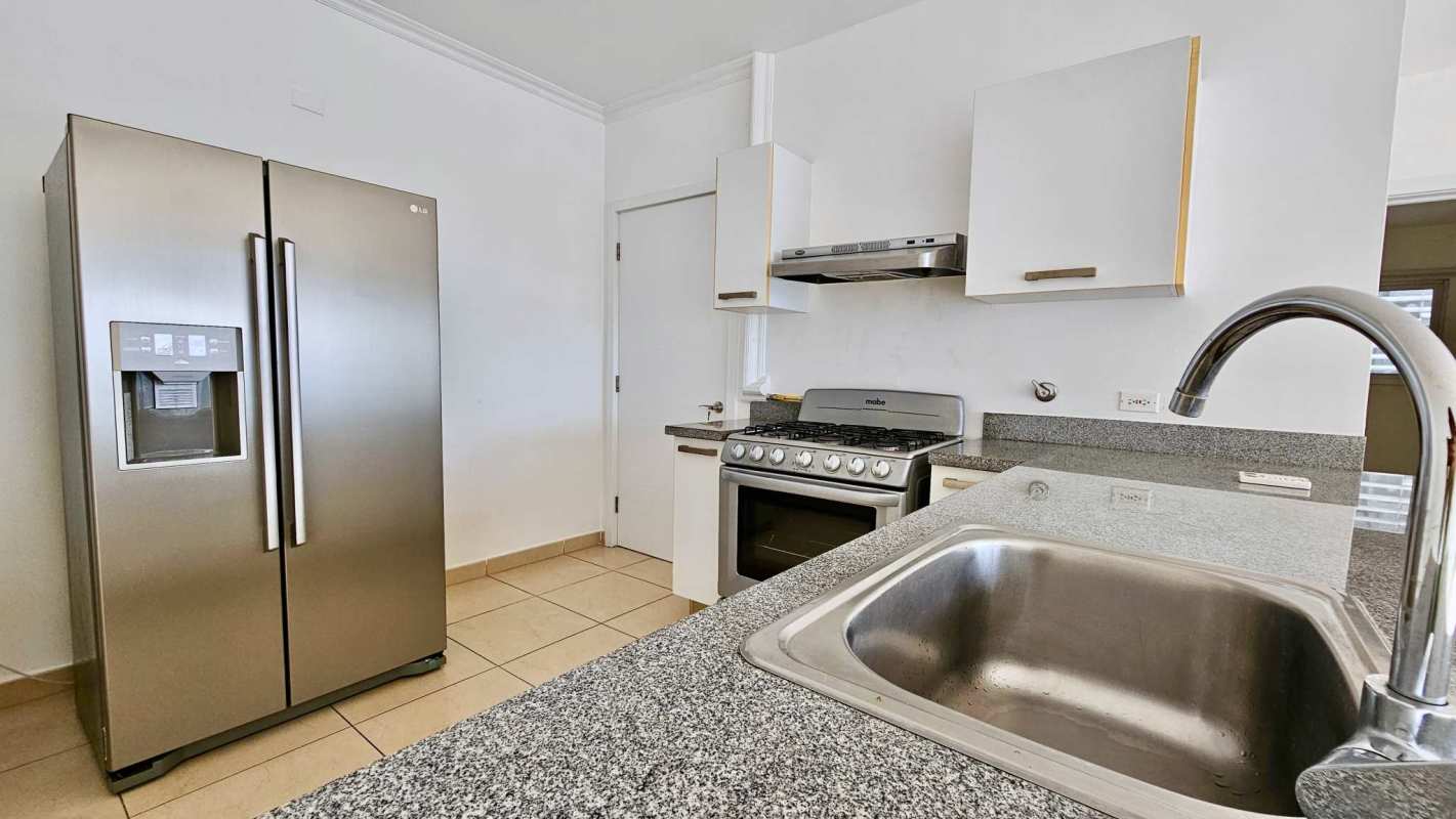 Kitchen in PH Waters with granite countertops, stainless appliances and ocean view window