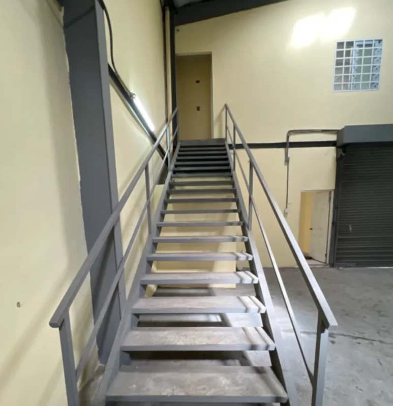 Interior view with metal staircase leading to mezzanine inside warehouse rental in Chanis Panama