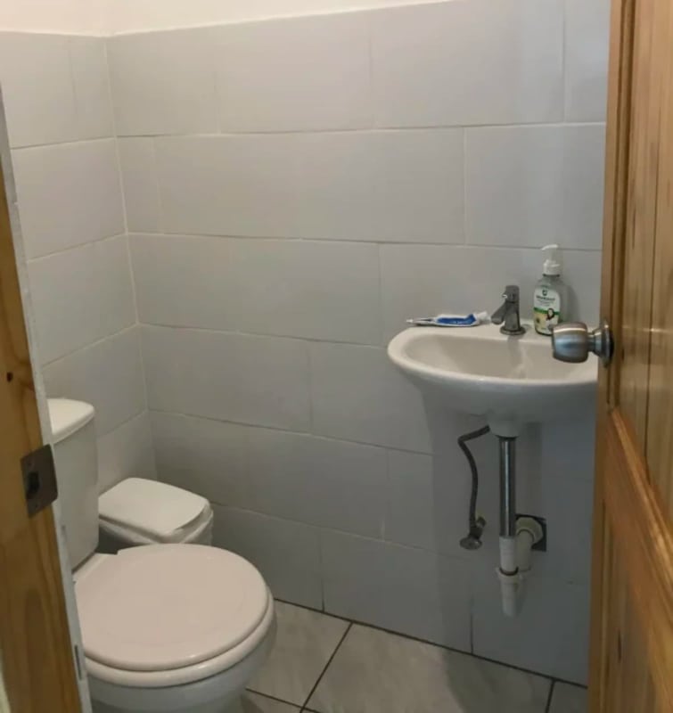 Minimal white tiled bathroom in commercial warehouse Parque Lefevre Panama