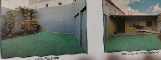 Enclosed backyard with artificial lawn, privacy walls, small garden, and covered patio area of house at Praderas de San Isidro, Puerto Pilón, Colón