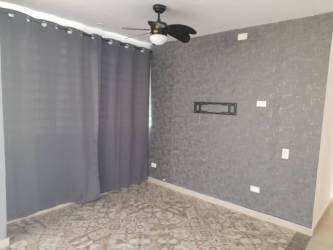 Living room with gray accent wall, ceiling fan, large windows at PH Pacific Hills Vera Cruz Arraiján rental