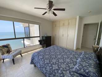 Balcony with orange cushioned furniture overlooking the ocean in Playa Malibu Panama