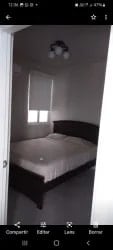 Simple bedroom with dark wood bed, white walls and window in PH Vista Azul Playa Dorada Panama