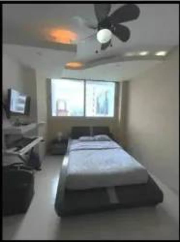 Modern bedroom with large window and city view at PH Pearl at the Sea Panama