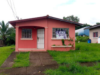 Basic bathroom with tiled walls, white sink, toilet and shower in house for sale Panama