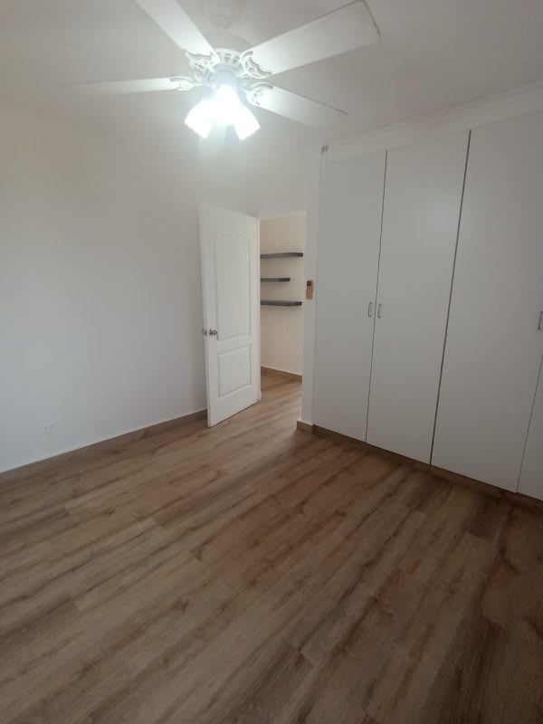 Spacious bedroom with built-in closet, wood floors, modern ceiling fan in PH La Loma Park Panama