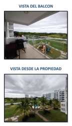 Covered balcony view of swimming pool, gardens and play area at Coral Reef Tower 5 Playa Blanca