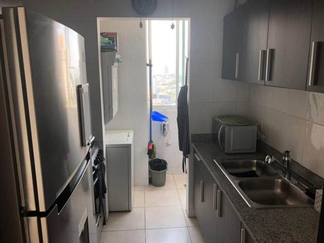 Narrow kitchen with granite counters, stainless appliances, laundry area PH Edison Park Panama City