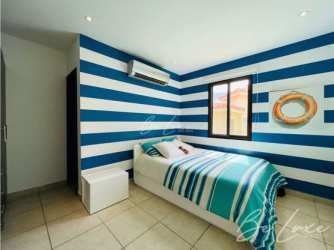 Secondary bedroom with large windows and garden view in Vista Mar luxury beach villa Panama