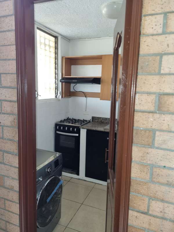 Compact kitchen with granite, gas stove, stacked laundry near Multiplaza Panama
