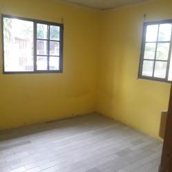 Sunny empty bedroom with yellow walls, two windows in house for rent El Ejido Los Santos Panama