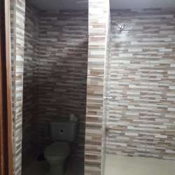 Bathroom interior with tile walls, shower area and toilet in house Los Santos Panama