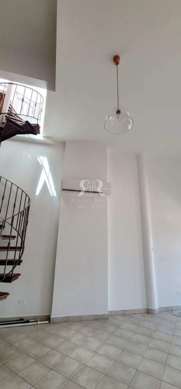 Minimalist living room with high ceiling and balcony doors in San Felipe