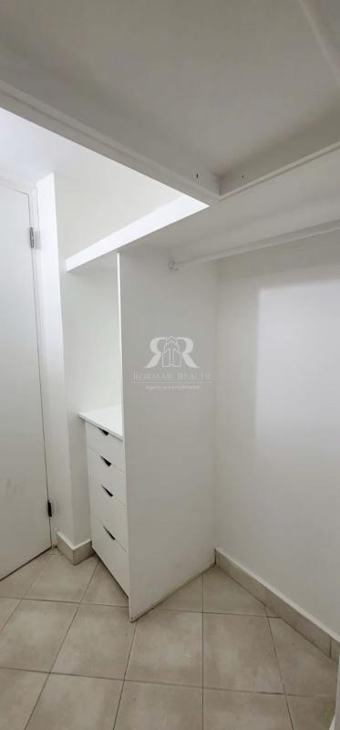 Modern white walk-in closet with built-in drawers in historic apartment