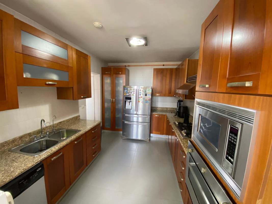 Modern kitchen with wood cabinetry, granite countertop and appliances in Tower 400 Panama