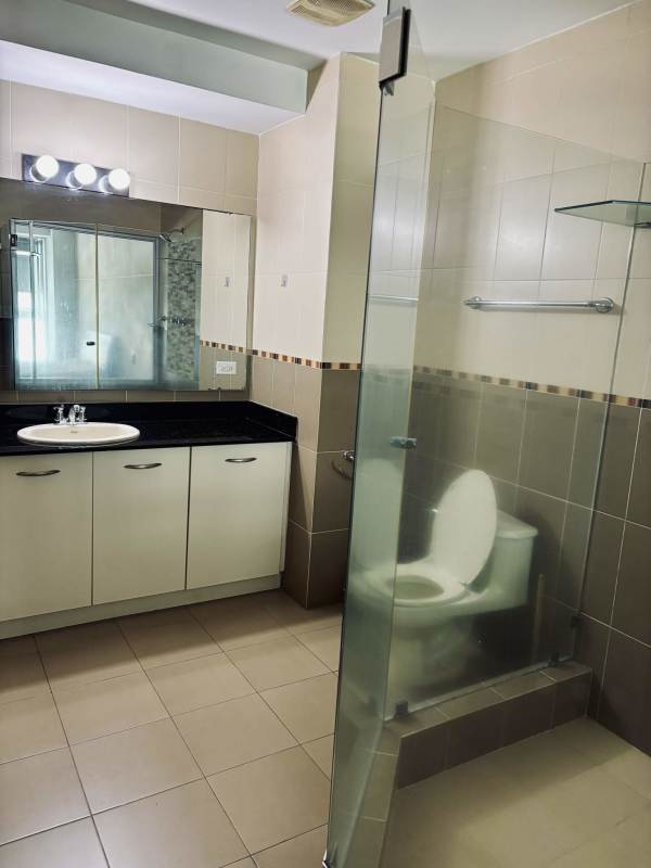 Modern bathroom with glass shower enclosure and granite vanity in PH Bayfront loft Panama City