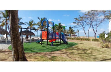 Beachfront condo building Aires del Mar white facade balconies tropical landscaping Playa Caracol