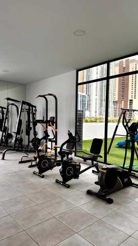 Building gym with fitness machines, floor to ceiling windows and city views PH The Gray apartment for rent Panama