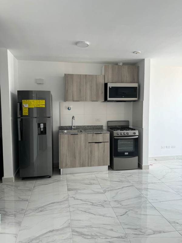 Spacious living room with large window and balcony access open to kitchen in PH The Gray Calle 50 Panama