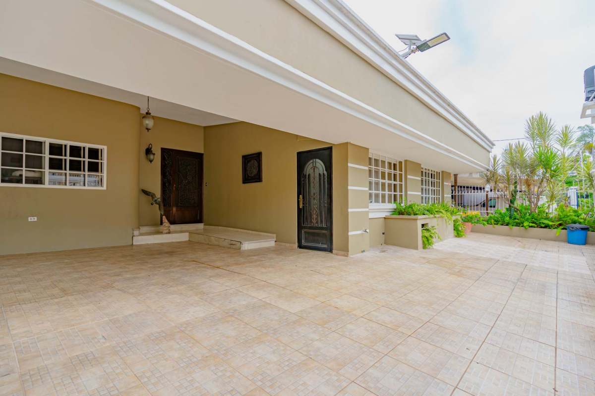 Living room with art, chandeliers, tray ceiling and neutral palette at La Loma Residence