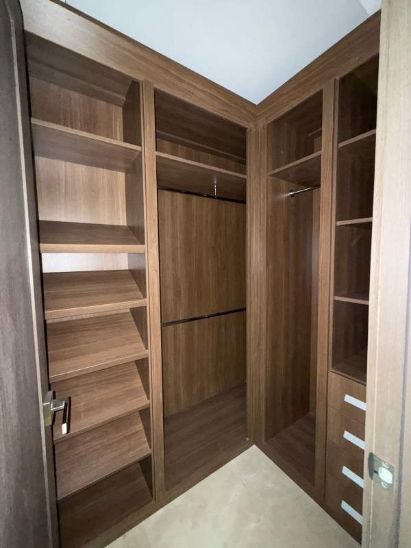 Modern walk-in closet with shelving and drawers in luxury condo Santa María