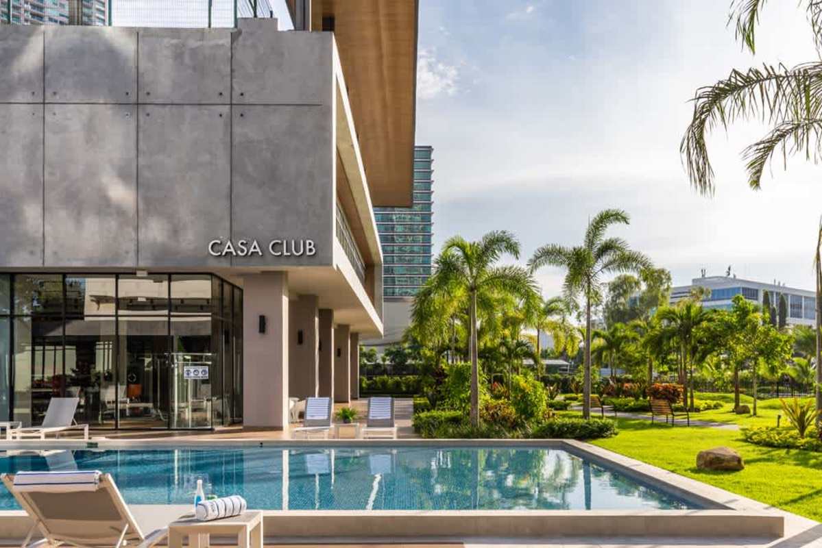 Modern clubhouse with palm trees, large pool, gardens Costa del Este Panama